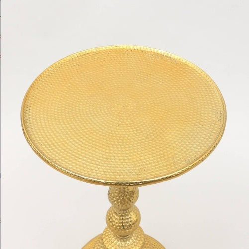 Round golden side table styled for living room or entryway accent close up 